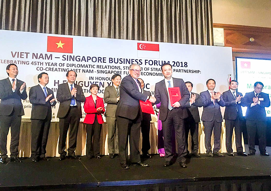 Đại diện Vietcombank, ông Phạm Quang Dũng – Tổng Giám đốc (hàng đầu, bên phải) và đại diện SBF, ông Ho Meng Kit – Giám đốc điều hành ký kết thỏa thuận hợp tác giữa hai bên.